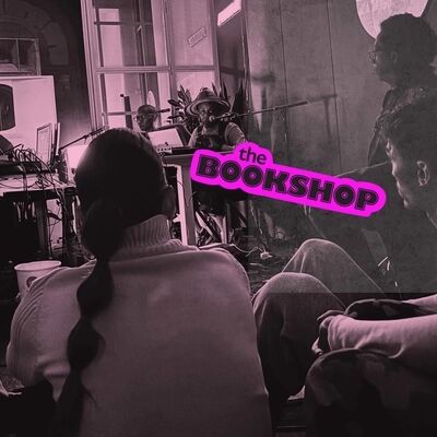 Beeld bij Electronic Music and the Present: een roze getinte foto van een optreden met elektronische muziek — twee muzikanten achter laptops en apparatuur, met toeschouwers op de voorgrond. Op het beeld staat het roze logo 'the BOOKSHOP'.